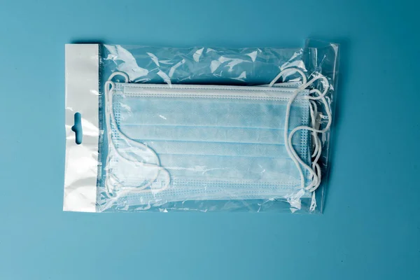 青い背景に医療用保護マスク コロナウイルス防止 ウイルス保護因子 医療用または外科用フェイスマスク ウイルス対策 呼吸マスク — ストック写真