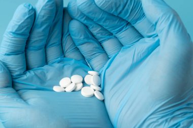 Doktorun elindeki haplar mavi arka planda.