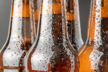 Kahverengi bir şişede soğuk bira ve cam yüzeyinde büyük su damlaları. Kara zanaat birası