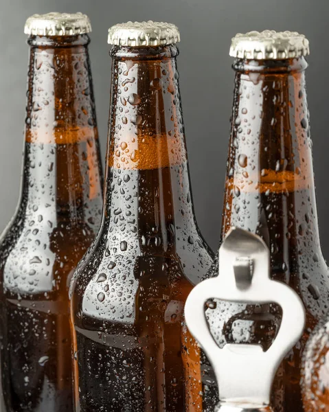 Cold beer in a brown bottle with large water drops on the glass surface. Dark craft beer