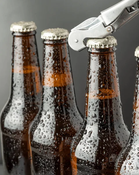 Cold beer in a brown bottle with large water drops on the glass surface. Dark craft beer