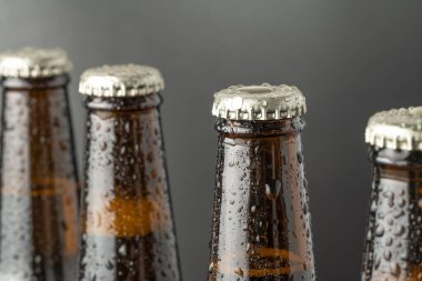 Kahverengi bir şişede soğuk bira ve cam yüzeyinde büyük su damlaları. Kara zanaat birası