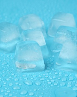 Mavi arka planda su damlaları olan buz küpleri