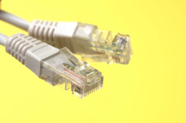 Ağ bağlantısı, internet bağlantısı ve bilgisayar teknolojisi konsepti, ethernet kablo bağlantısına yakın çekim, sarı arkaplanda