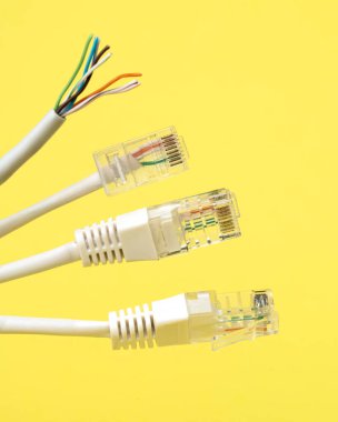 Ağ bağlantısı, internet bağlantısı ve bilgisayar teknolojisi konsepti, ethernet kablo bağlantısına yakın çekim, sarı arkaplanda