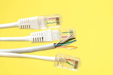 Ağ bağlantısı, internet bağlantısı ve bilgisayar teknolojisi konsepti, ethernet kablo bağlantısına yakın çekim, sarı arkaplanda
