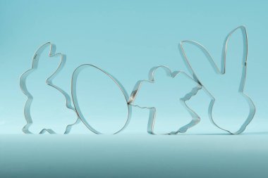 Easter bunny on blue background. Happy Easter Day concept. Minimal Easter concept. Space for text. Easter Cookie Cutter on baking background.