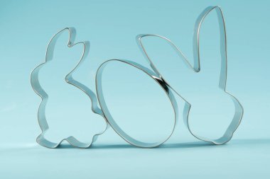 Easter bunny on blue background. Happy Easter Day concept. Minimal Easter concept. Space for text. Easter Cookie Cutter on baking background.