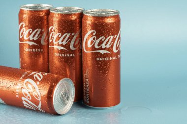 Ukraine, Kiev - January 19, 2023: Cold can of Coca-Cola drink on blue background with water drops