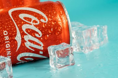 Ukraine, Kiev - January 19, 2023: Cold can of Coca-Cola drink on blue background with water drops