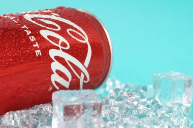 Ukraine, Kiev - January 19, 2023: Cold can of Coca-Cola drink on blue background with water drops