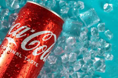 Ukraine, Kiev - January 19, 2023: Cold can of Coca-Cola drink on blue background with water drops