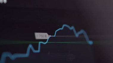 Buying stocks in the investment market in close-up. Checking data in the financial market. Using your phone to analyze a rising stock fund. Displaying a stock market chart on a touch screen monitor.