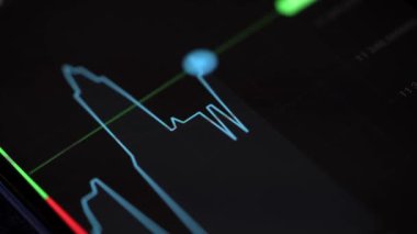 Buying stocks in the investment market in close-up. Checking data in the financial market. Using your phone to analyze a rising stock fund. Displaying a stock market chart on a touch screen monitor.
