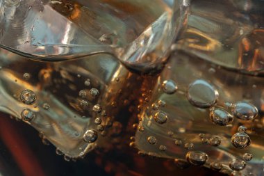 Coke or club soda poured into a glass with ice cubes