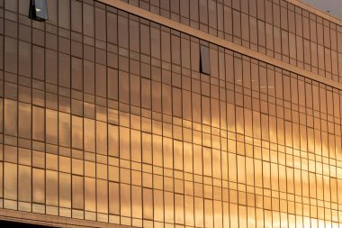 Modern office building facade. Tall business center with a glass facade. Construction of a glass facade structure. The glare of the sun on the glass wall of a skyscraper