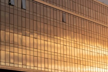 Modern office building facade. Tall business center with a glass facade. Construction of a glass facade structure. The glare of the sun on the glass wall of a skyscraper