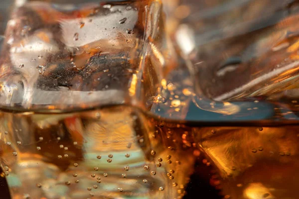 Coke or club soda poured into a glass with ice cubes
