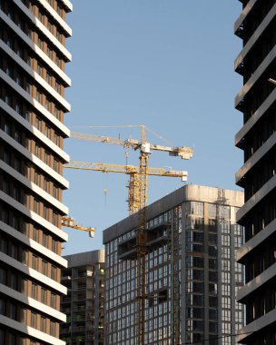 Unloading cargo and loading cargo with a crane. Crane boom and hook against the sky with engineering details and knots.