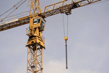Crane and construction site against the blue sky. Working on large construction sites, and many cranes working in the new construction business.