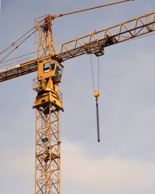 Crane and construction site against the blue sky. Working on large construction sites, and many cranes working in the new construction business.