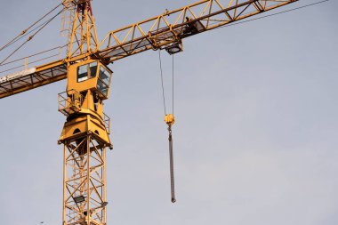 Crane and construction site against the blue sky. Working on large construction sites, and many cranes working in the new construction business.