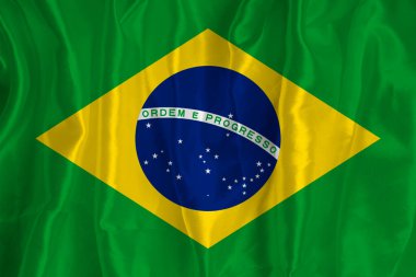 The flag of Brazil on a silk background is a great national symbol. Fabric texture The official state symbol of the country.