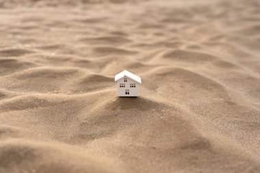 Kumlu bir dalgada ahşap bir evin yakın çekimi.