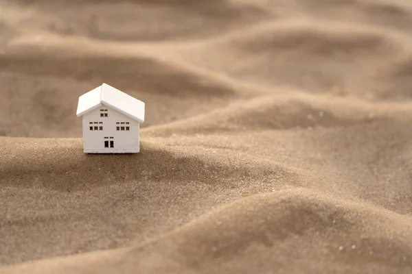 stock image Close-up of a model of a wooden house on a sandy wave
