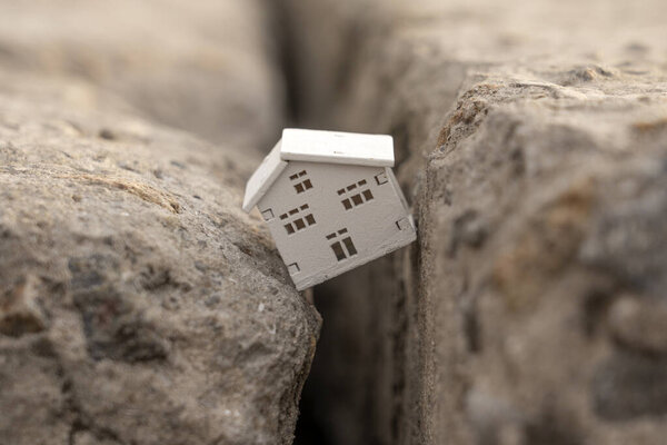 Дом упал в трещину во время землетрясения. Концепция страхования недвижимости от землетрясения