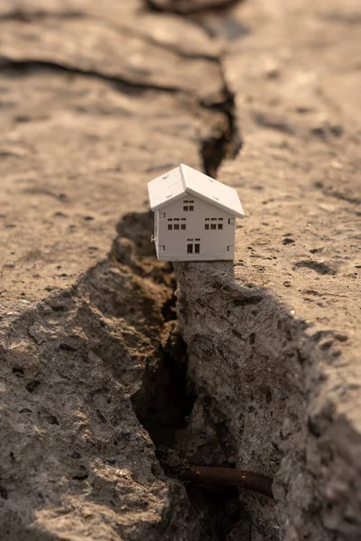 stock image The house fell into a crack during an earthquake. Earthquake home insurance concept Real estate fall