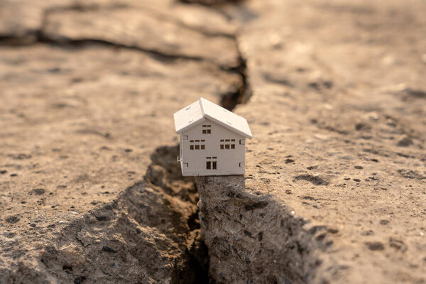 Дом упал в трещину во время землетрясения. Концепция страхования недвижимости от землетрясения