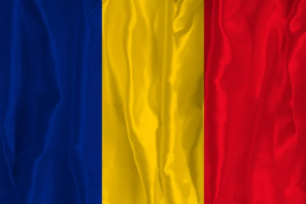 The Romanian flag on a silk background is a great national symbol. Texture of fabrics The official state symbol of the country