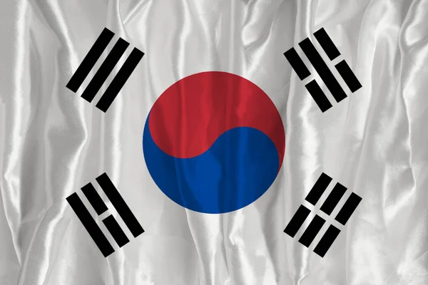 The flag of South Korea on a silk background is a great national symbol. Texture of fabrics The official state symbol of the country