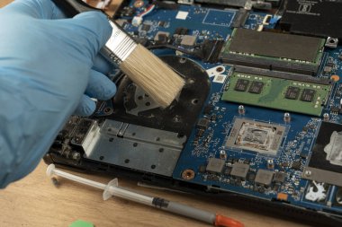 Bir teknisyen bozuk bir dizüstü bilgisayarı tornavidayla tamir eder. Not defteri bileşenleri ve parçalar yakın plan