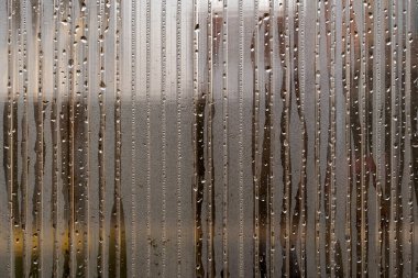 Su damlaları. Duş buharının yoğunluğu şeffaf cama damlıyor, pencereye yağmur damlaları damlıyor. Yağmur damlaları