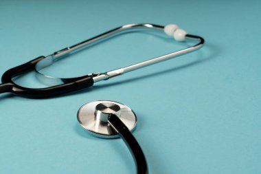 Mavi arka planda siyah steteskop. Tıp sembolü.