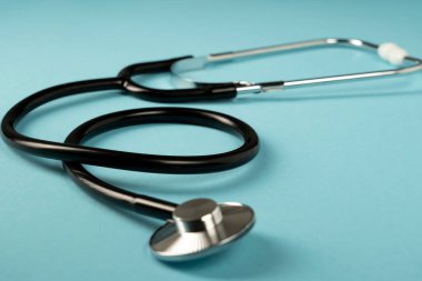 Mavi arka planda siyah steteskop. Tıp sembolü.