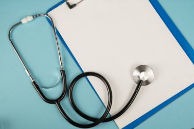 Mavi arka planda siyah steteskop. Tıp sembolü.