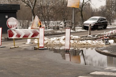 Yol ve kamu hizmetlerinin inşası şehirdeki trafiği engelliyor. Arka planda makine ve ekipman olan yol tamiri tabelası. Yol kavramı işe yarıyor..
