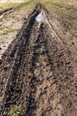 Kirli, geçilemez yol. Sonbahar ormanında off-road pisti. Buzlu sonbahar yolundaki derin rutubetler. Yağmurlu bir günde ıslak, çamurlu kırsal yol Bahar dağlarında kırsal yol çamurlu su birikintileriyle dolu