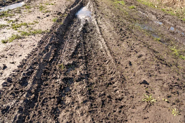 stock image Dirty impassable road. Off-road track in the autumn forest. Deep ruts on a slushy autumn road. Wet muddy countryside road on a rainy day Broken country road in spring mountains with many muddy puddles