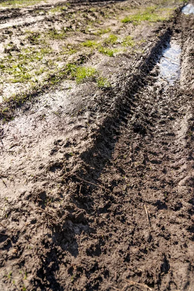 Kirli, geçilemez yol. Sonbahar ormanında off-road pisti. Buzlu sonbahar yolundaki derin rutubetler. Yağmurlu bir günde ıslak, çamurlu kırsal yol Bahar dağlarında kırsal yol çamurlu su birikintileriyle dolu