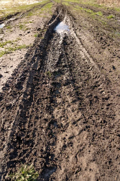 Kirli, geçilemez yol. Sonbahar ormanında off-road pisti. Buzlu sonbahar yolundaki derin rutubetler. Yağmurlu bir günde ıslak, çamurlu kırsal yol Bahar dağlarında kırsal yol çamurlu su birikintileriyle dolu