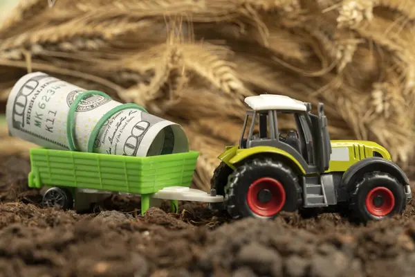 Arkaplanda buğday filizi olan bir traktör. Tahıl ve tarım ihracatı. Tarım ürünleri için artan fiyatlar