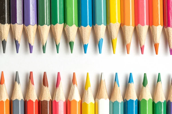 Colored pencils lie in a row. A line drawn with pencil tips. Set of crayons for illustrations, art, study. Ready for school.