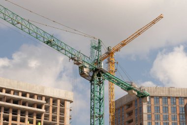 İnşaat alanı ve şehir arka planında kule vinçleri