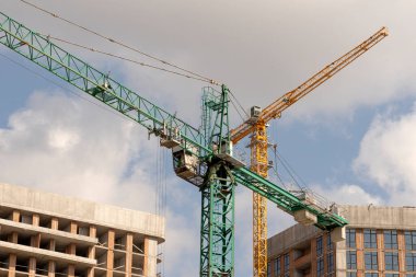 İnşaat alanı ve şehir arka planında kule vinçleri