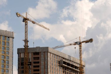 İnşaat alanı ve şehir arka planında kule vinçleri