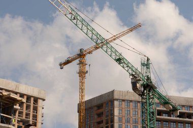 İnşaat alanı ve şehir arka planında kule vinçleri